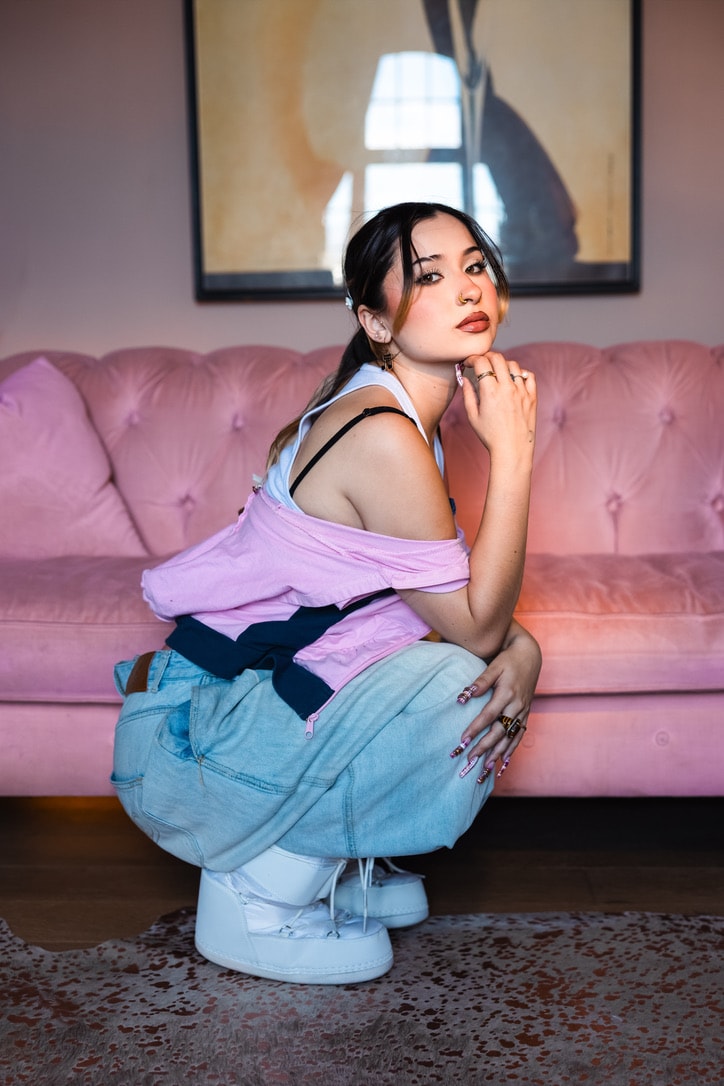 Sienna Melgoza seated in front of a pink sofa